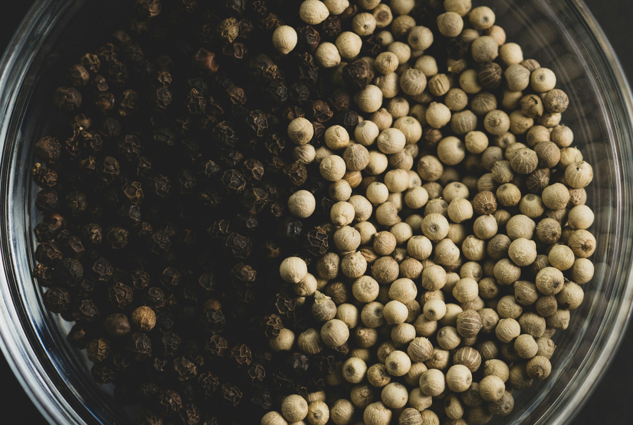 Black and white peppercorns in a jar