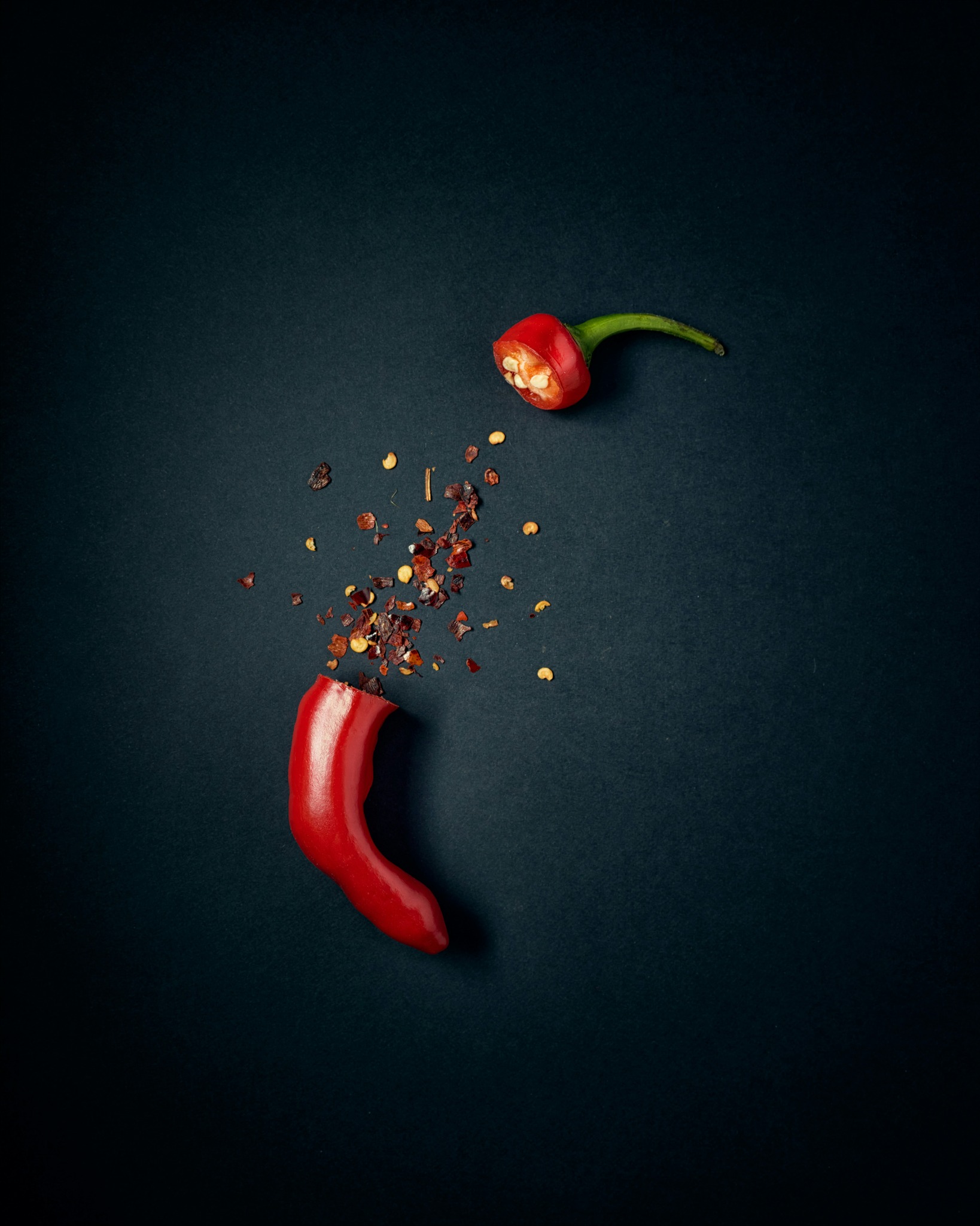 Red chilli with flakes on a dark background