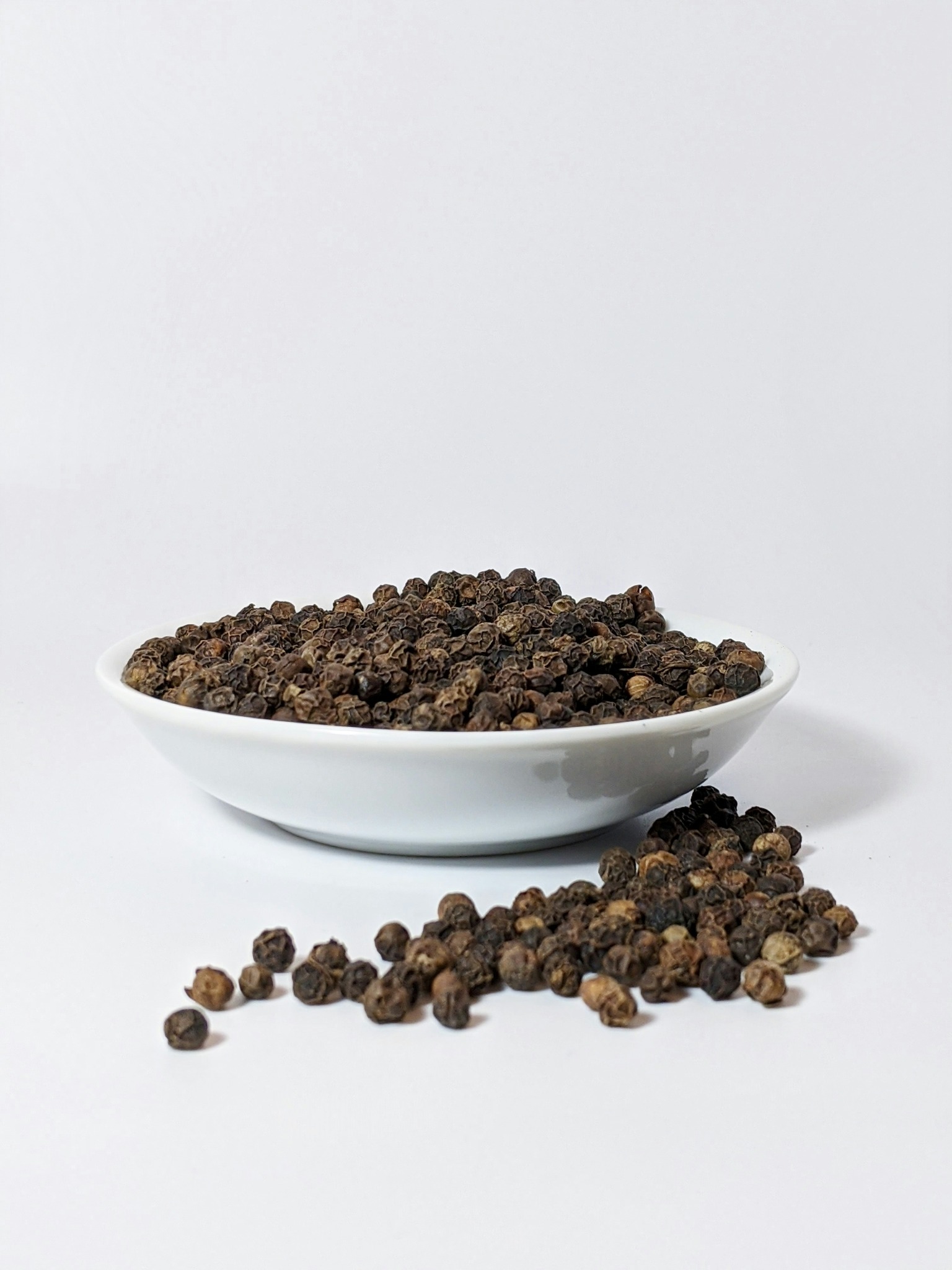 Peppercorns in a white bowl